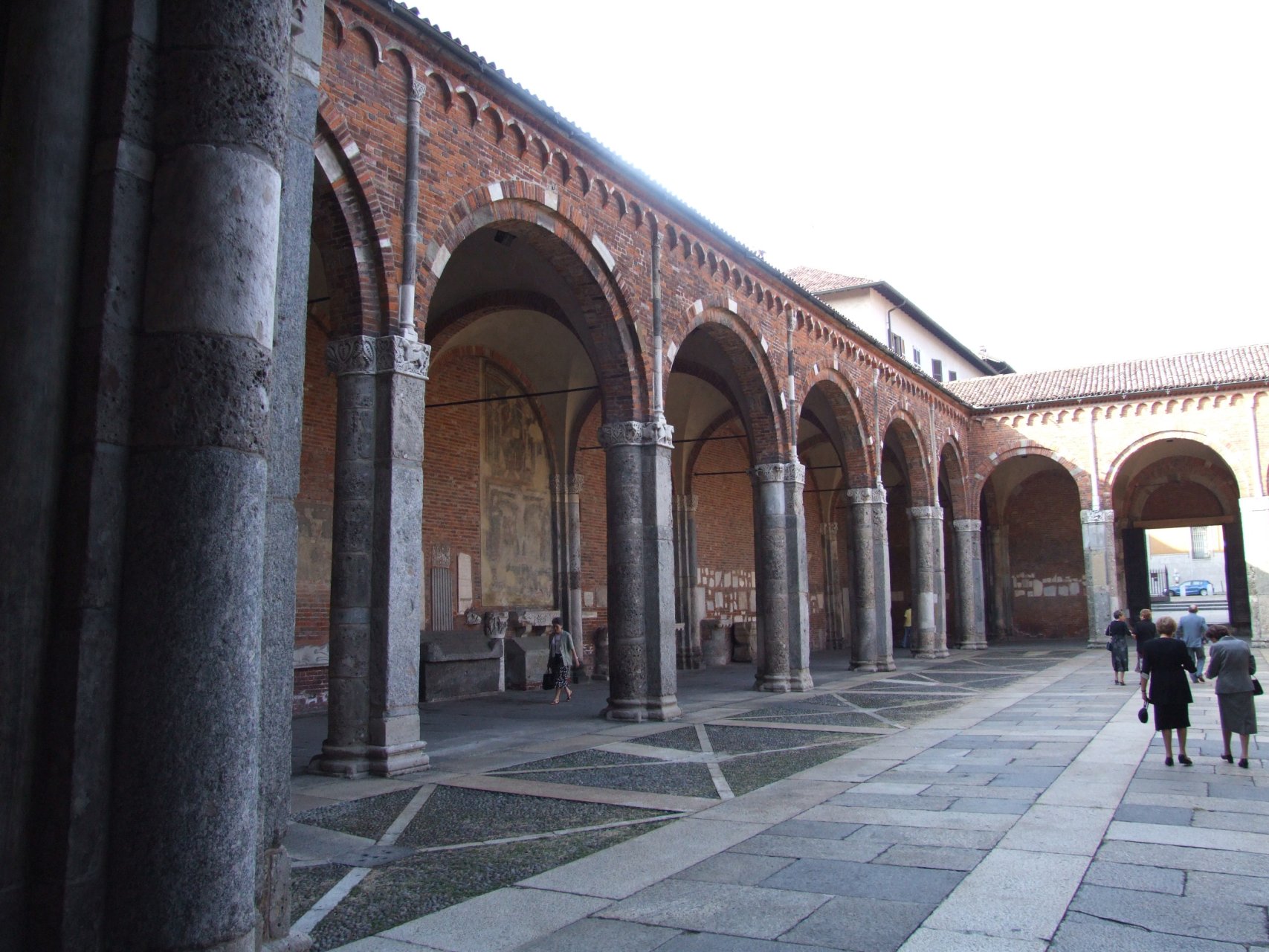 Dziedziniec kościoła Saint'Ambrogio otoczony jest przez romańskie krużganki