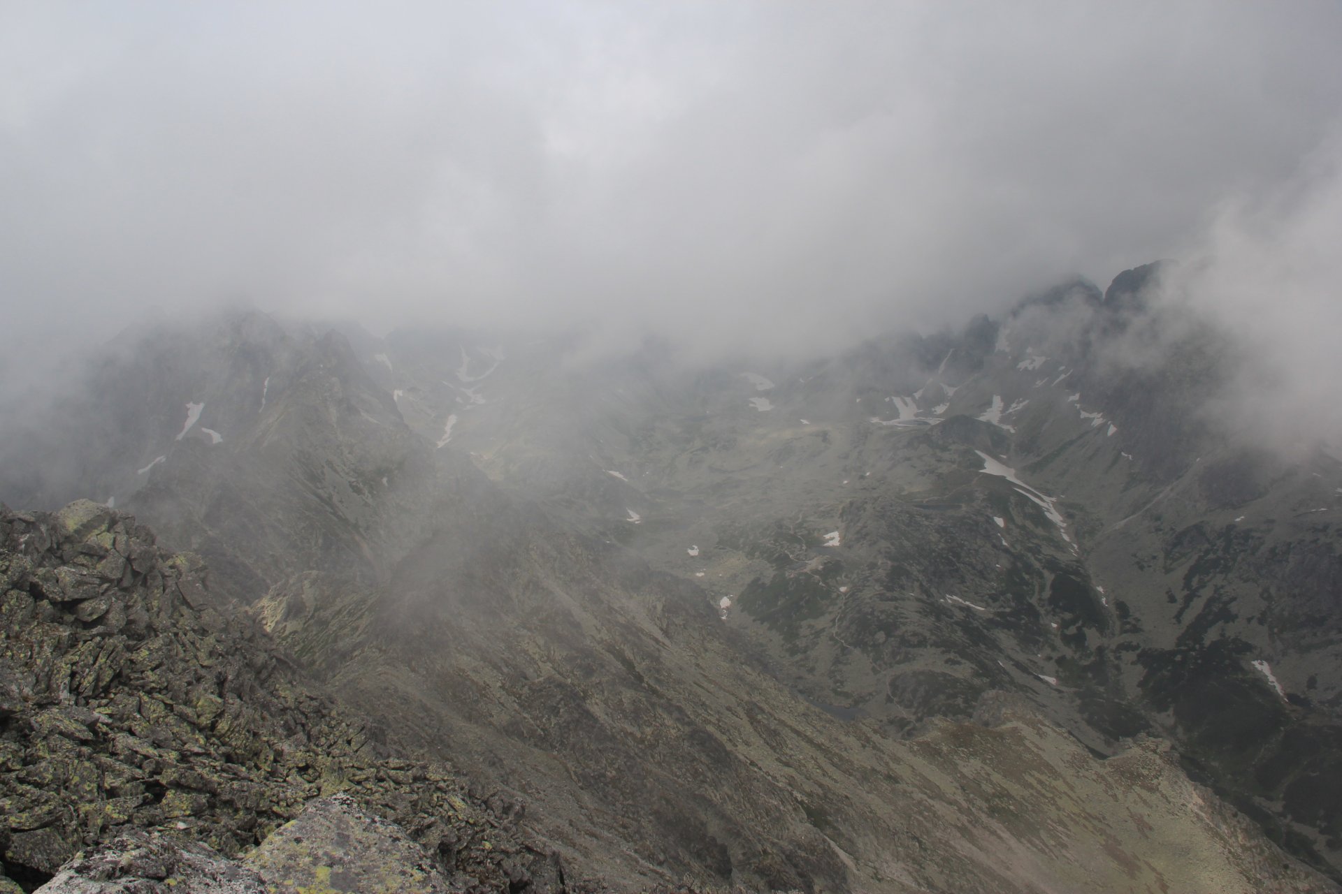 Widok ze Sławkowskiego Szczytu na schowane w chmurach Tatry Wysokie