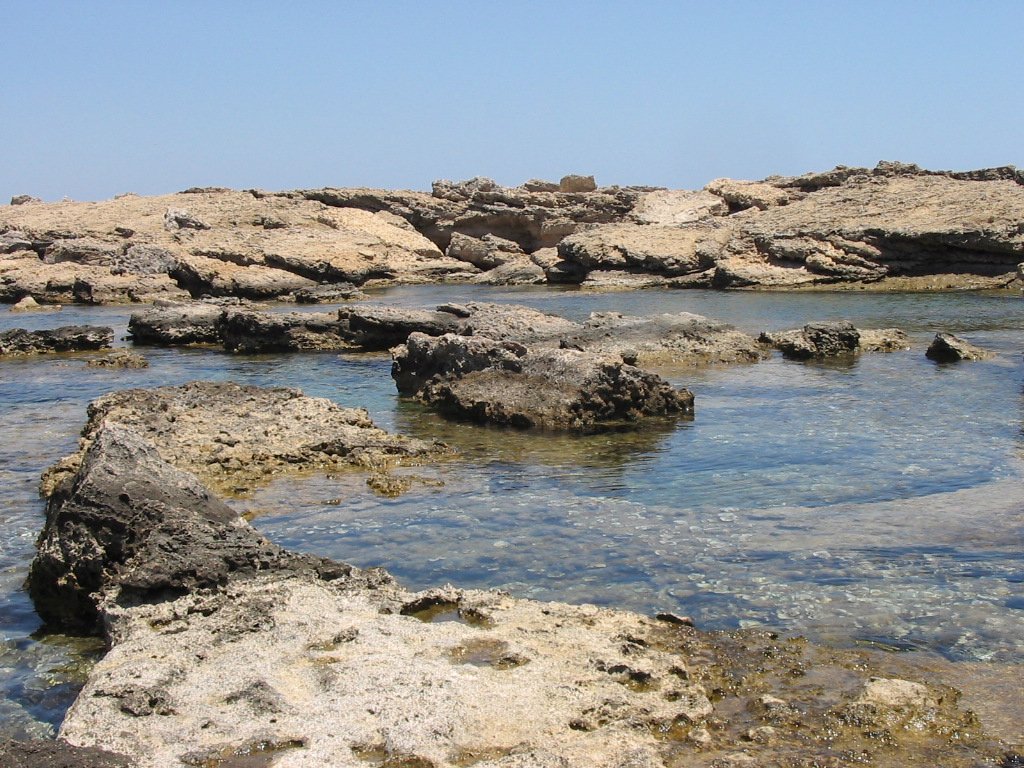 Rafa koralowa i wulkaniczne skały w zatoce Agia Marina